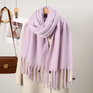 Détail de la texture de l'écharpe en tricot lilas clair avec de longues franges