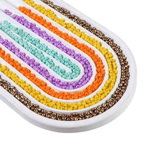 Rainbow-colored 2-4mm glass seed beads for DIY jewelry making in a curved white tray