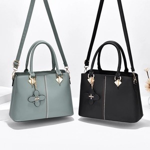 Classic structured handbag in grey-blue and black with gold hardware and clover charm