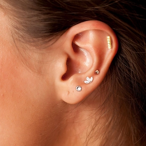 Detail of S925 silver ear cuff set with geometric zircons and pearls on ear