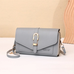 Detail of grey crossbody phone bag showing U-shaped gold buckle and smooth faux leather
