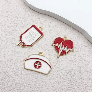 Close-up of enamel blood bag, heart with EKG, and nurse hat charms for DIY jewelry