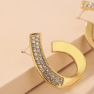 Detail of gold waterdrop stud earrings with two rows of sparkling clear rhinestones