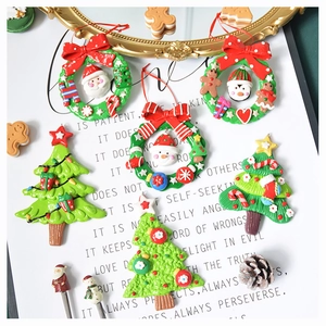 Detailed view of polymer clay Christmas tree ornaments and festive wreaths on a poetic board