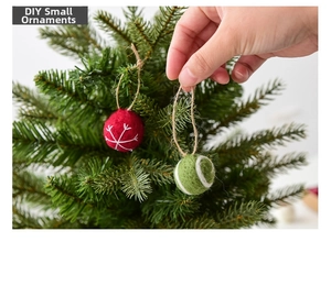Detail of wool felt Christmas ornaments with embroidery hanging on a festive tree branch