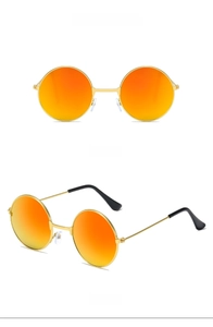 Details einer runden Retro-Kinder-Sonnenbrille mit Goldrahmen und roten Gläsern