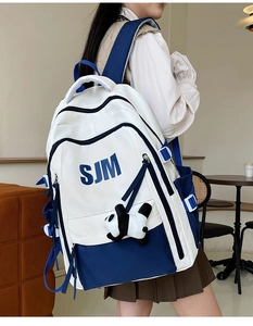 Detail view of American vintage backpack in navy and white with a cute panda pendant