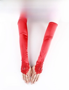 Detailed close-up of red satin bridal gloves with lace embroidery and sequins