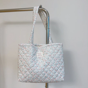 Détail du sac en coton matelassé à fleurs avec surpiqûres losanges et étiquette en tissu