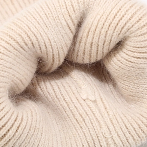 Close-up of beige ribbed knit texture showing soft angora rabbit hair luxury fibers