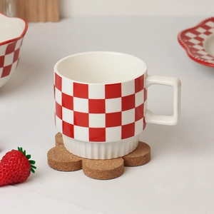 Minimalist red and white checkered ceramic mug with striped base on flower cork coaster