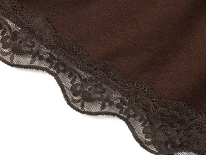 Gros plan sur la dentelle délicate et les coutures du tissu en maille marron foncé