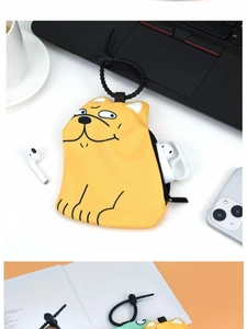 Macro shot of a yellow cartoon dog storage pouch on a desk with a plastic hanging hook