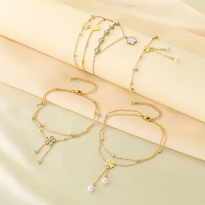 Detailed view of gold stainless steel anklets with clover, heart and pearl charms