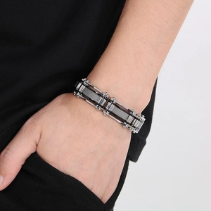 Detail view of men's industrial mesh bracelet with silver metal frame and bolt details