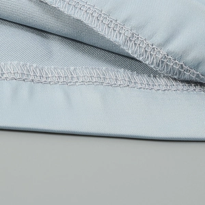 Detail view of high-quality stitching and silky satin texture on light blue jumpsuit