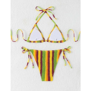 Detailed view of smocked textured fabric and colorful striped bikini set on white background