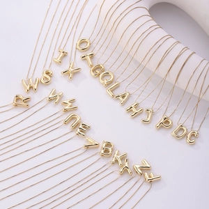Detailed array of 3D balloon alphabet pendants in polished gold finish