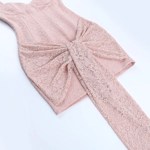 Close-up of pink lace dress showing intricate floral textures and front knot detail