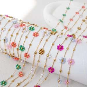 Bohemian colorful beaded flower necklace and bracelet set on a white cylinder display