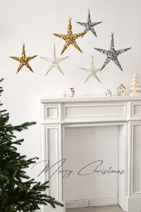 Detail view of 6 pieces glittered metal star ornaments hanging on a white fireplace
