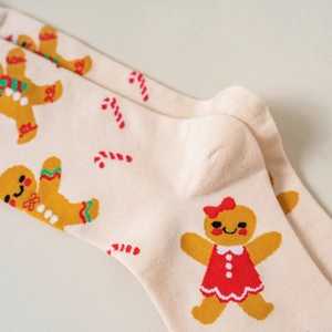 Detail shot of knitted Christmas socks featuring gingerbread man and candy cane patterns