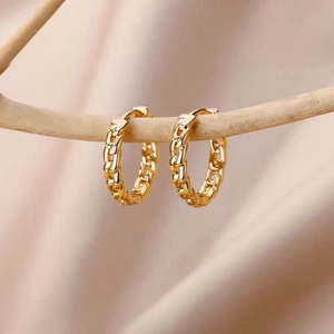 Elegant 18K gold-plated textured hoop earrings displayed on a natural wooden branch