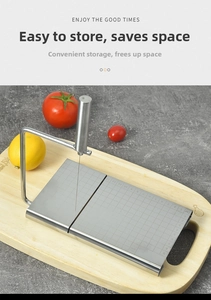Detail of stainless steel cheese slicer with measurement scale on a wooden board