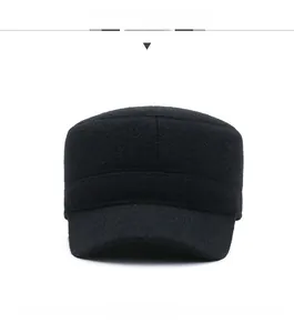 Detailed front view of black winter flat top cap with sport metal emblem and thick wool fabric