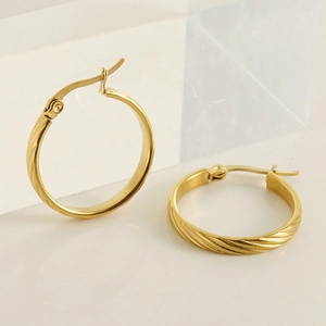 Detail of 18K gold stainless steel hoop earrings with textured spiral design on a white base