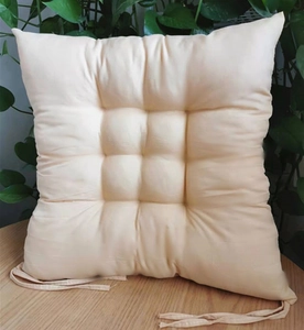 Detail of beige square chair cushion with nine-hole quilting and matching secure ties