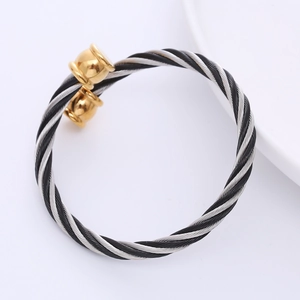 Three-tone twisted cable wire bangle in stainless steel with gold spherical end caps