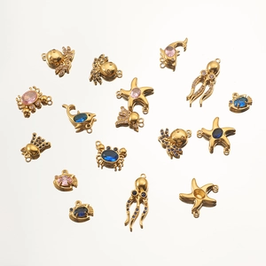 Detail of 18K gold plated starfish and octopus charms with pink and blue crystals