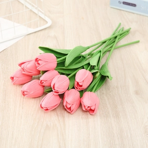 A bouquet of 10 lifelike pink PU tulips arranged on a rustic wooden tabletop