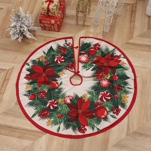 Detail of white Christmas tree skirt with festive wreath patterns and red ribbon ties