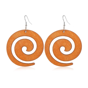 Macro shot of brown wooden spiral earrings with silver hooks on white background