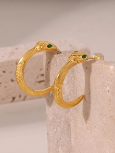Détail de la texture des écailles et des yeux en gemme verte sur la boucle d'oreille serpent