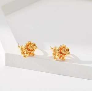 Modern 18K gold-plated brass earrings with irregular C-shaped flower design on white stand