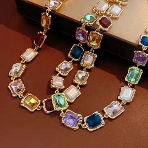 Macro detail of vintage gold necklace with multi-colored square crystals on leather