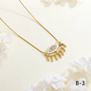 Detailed close-up of a gold Evil Eye necklace with white enamel and sparkling zircon accents