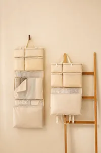 Dettaglio dell'organizzatore da viaggio beige con tasche in rete e chiusure a cerniera