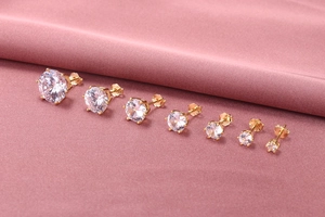 Detailed set of seven gold six-prong stud earrings with round zircons in various sizes