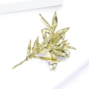 Detailed back view of golden floral brooch showing sturdy safety pin and metal texture