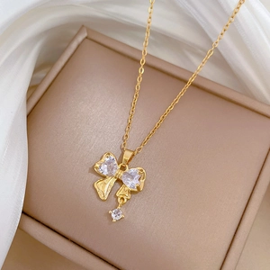 Titanium steel bow pendant necklace with zircons displayed on a beige jewelry gift box