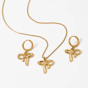 Elegant gold bow necklace and earrings jewelry set for women on white background