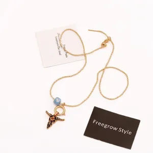 Bohemian gold beaded necklace with evil eye and vintage bull head pendant on white background