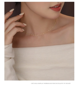Close-up of elegant gold water wave chain necklace worn on collarbone for women