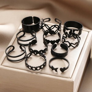 Macro view of 10-piece black ring set featuring heart and butterfly punk designs