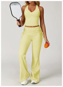 Detail of high waisted flared sports pants with drawstring side design in pale yellow color