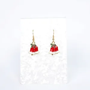 Close-up of festive Christmas bell earrings with red bells and green bow detail